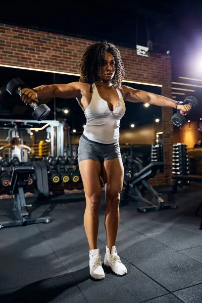 Photo of Fit sporty lady exercising with hand weights