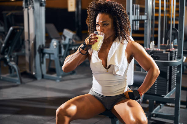 istock Female bodybuilder taking a sip of a protein drink 1289416131