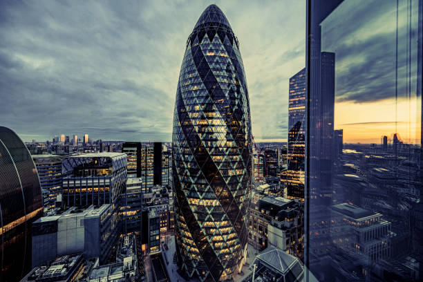 日没時のロンドン市の照明付きオフィスビル - 30 st mary axe ストックフォトと画像