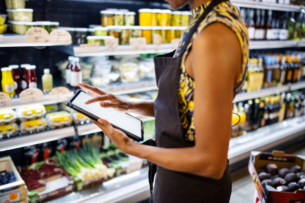 Sales clerk checking inventory in delicatessen