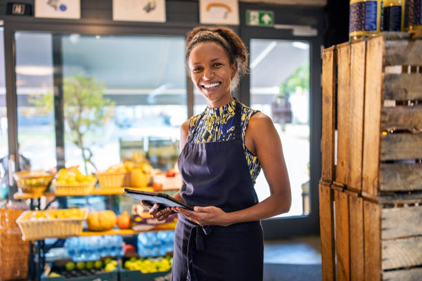 istock Smiling female owner with tablet PC in deli 1289417491