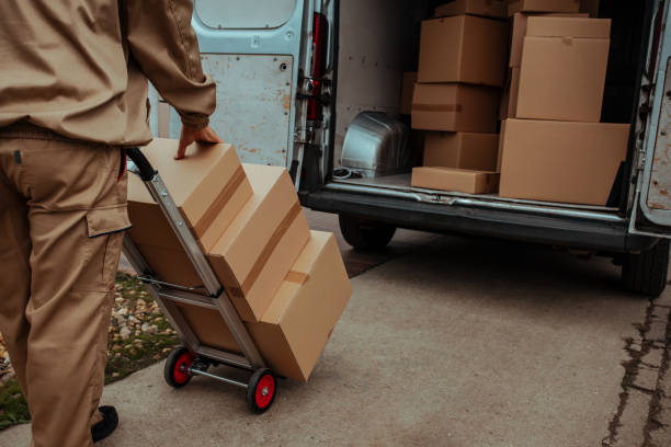 istock Delivery man packing cardboard boxes in van 1289420503