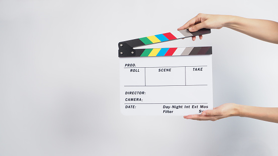 Hand is holding Clapper board or movie slate. it is used in video production and film industry on white background.