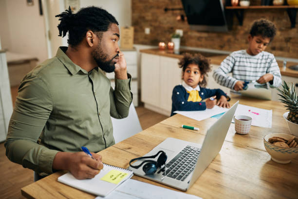 African American stay at home father working at home.
