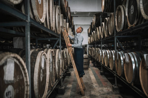 istock Senior man examining barrels in cellar. 1289422046