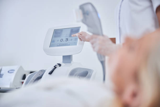 istock Female cosmetologist hands with ultrasound face machine 1289422599