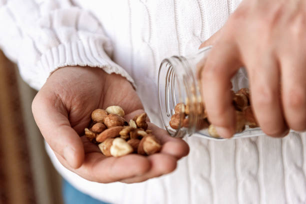 kuvapankkikuvat ja rojaltivapaat kuvat aiheesta mies pitelee purkkia saksanpähkinöitä hasselpähkinöitä ja manteleita - handful