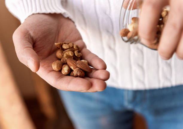 istock The man is holding a jar of walnuts hazelnuts and almonds 1289424866