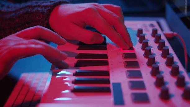 istock Hands using midi keyboard in home studio in night with neon lights 1289425168