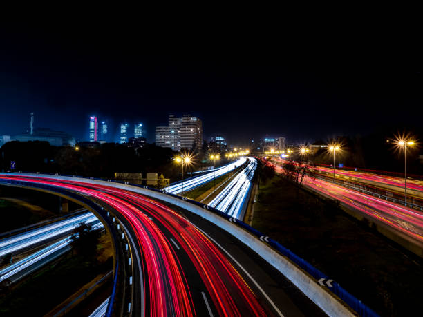 Light trails produced at dusk by the headlights and tail lights of cars from a bridge Light trails produced at dusk by the headlights and tail lights of cars from a bridge reflector stock pictures, royalty-free photos & images