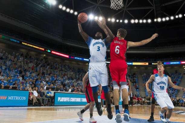 istock Basketball player jumping to score slam dunk 1289431189