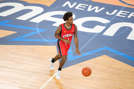 Basketball player in red jersey playing in court.