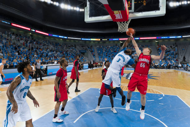 istock Basketball player jumping to score slam dunk 1289431203