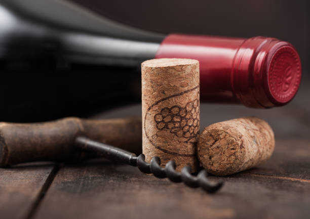 corchos de vino con sacacorchos vintage y botella de vino tinto sobre fondo de madera. - cork wine corkscrew old fotografías e imágenes de stock