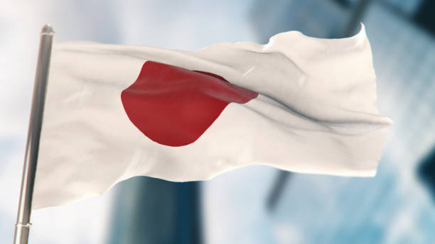 bandera nacional de japón contra edificios desenfocados de la ciudad - japanese flag fotos fotografías e imágenes de stock