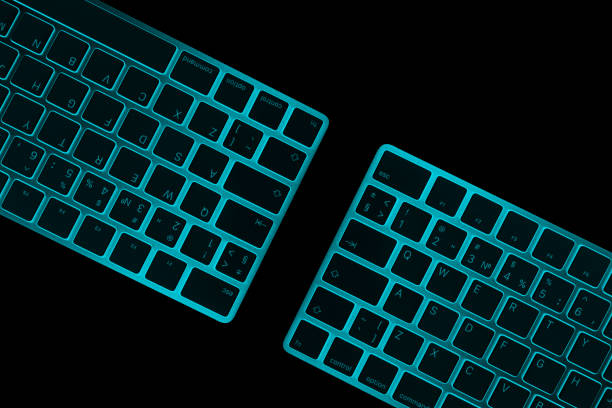 istock Closeup of a two modern blue computer keyboard keys isolated on black background. Close up view of a business workplace with wireless computer keyboard. Top view 1289432843