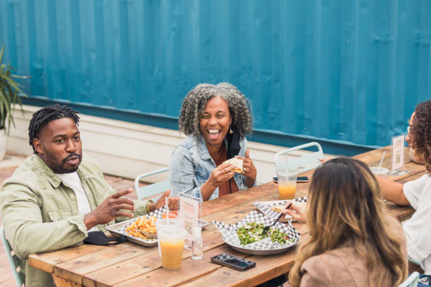 istock Multi-ethnic group of friends laughs together over lunch 1289433017