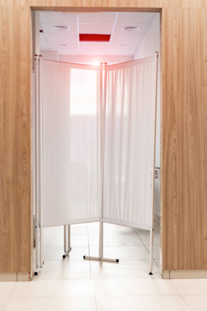 istock Folding screen is standing behind the door. Light wooden door and white folding screen. 1289433327