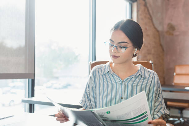 une femme d’affaires examine les documents - instruction manual photos et images de collection