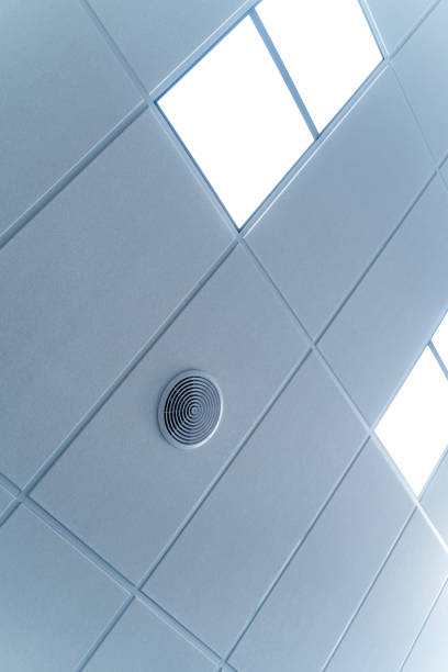 istock Fluorescent lamps on the modern ceiling. Luminous ceiling of square tiles. 1289435475
