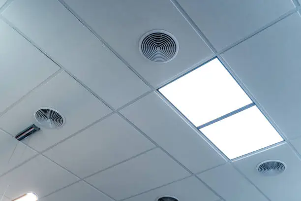 White office ceiling with built-in fluorescent lamp. Two led lamps on the celing.