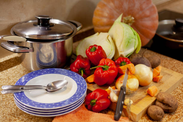 istock Set of vegetables saucepan and plates on marble table top 1289439260