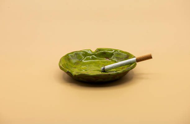 istock cigarette in green ceramic ashtray on beige background 1289439350