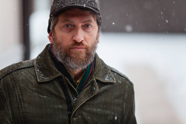 Man with beard stands on winter street man with a beard and a green jacket stands on the street on a winter day corduroy jacket stock pictures, royalty-free photos & images