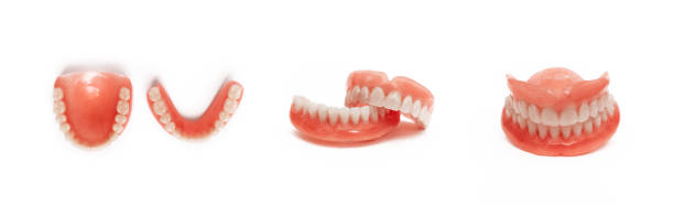 Dentures on a white background. Close-up of dentures. Dentistry is conceptual photography. Prosthetic dentistry. False teeth. Prosthetics. Close-up of plastic dentures. Teeth on a white background stock photo