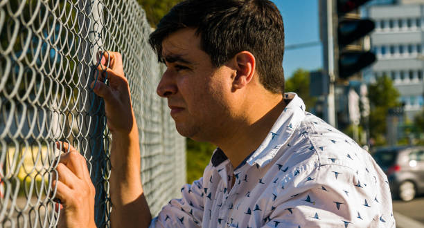 istock Teary Caucasian Man Holding Fence 1289442883