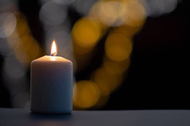istock Burning candle on black background with bokeh. Christian Christmas concept. 1289443894