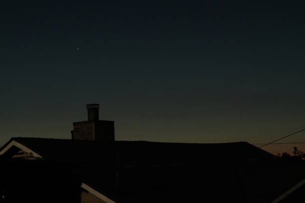 istock Rooftop and chimney of house against dawn sky 1289450107