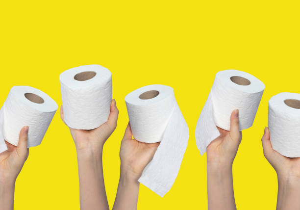 istock Hands holding toilet paper rolls on yellow background 1289451012