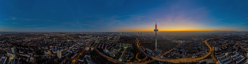 Panoramic drone image of the Frankfurt skyline with television tower in the evening during a colorful and impressive sunset in winter