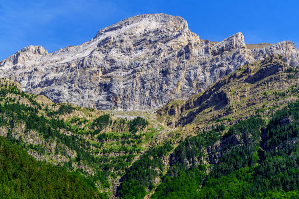 istock High mountain summit, vertical rock wall in Pyrenees Ordesa. Challenge overcoming achieve the impossible. 1289454082