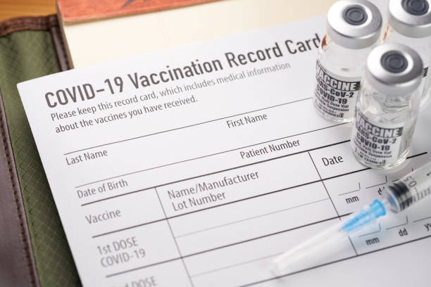 Covid-19 vaccination record card with vials and syringe. Covid-19 vaccination record card with vials and syringe. immunization certificate photos stock pictures, royalty-free photos & images