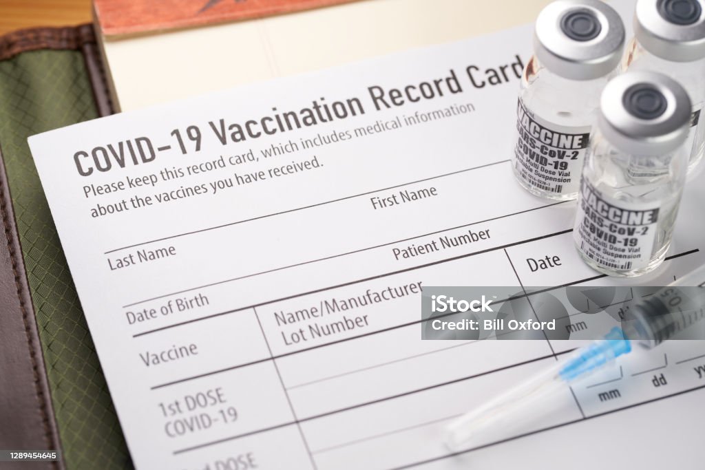 Covid-19 疫苗接種記錄卡，帶小瓶和注射器。輝瑞、現代、強生 - 免版稅COVID-19疫苗圖庫照片