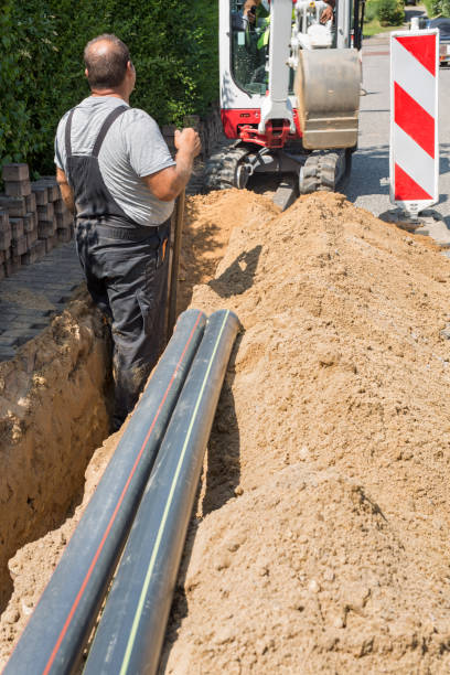istock Workers installing optical fibre cables in shallow trenches. 1289458813