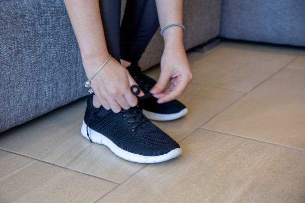 istock woman tying up her sneakers 1289459647