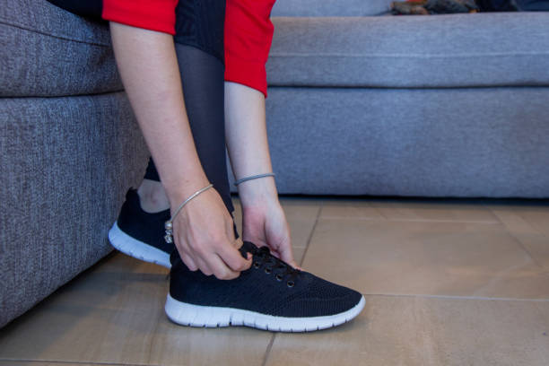 istock woman tying up her sneakers 1289459674