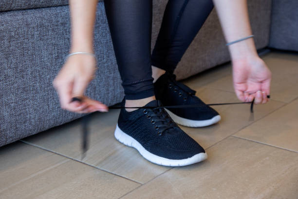 istock woman tying up her sneakers 1289459862
