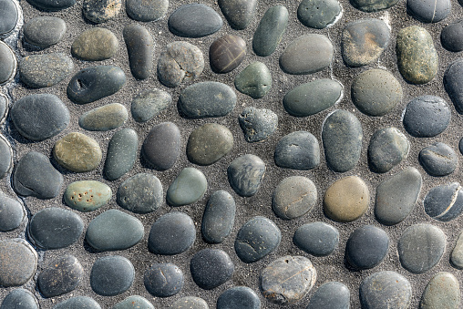 Multicolor pebbles background surface under sunlight.