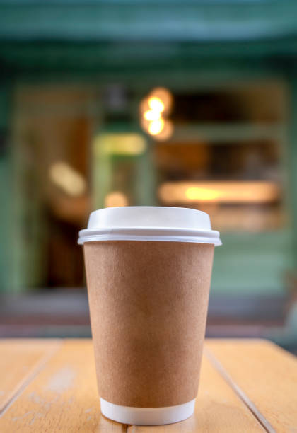 Coffee paper cup on wood table in coffee cafe.