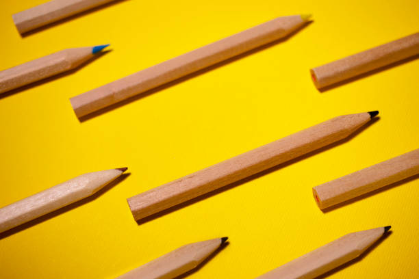 istock Pattern of colored pencils on a yellow background 1289473526