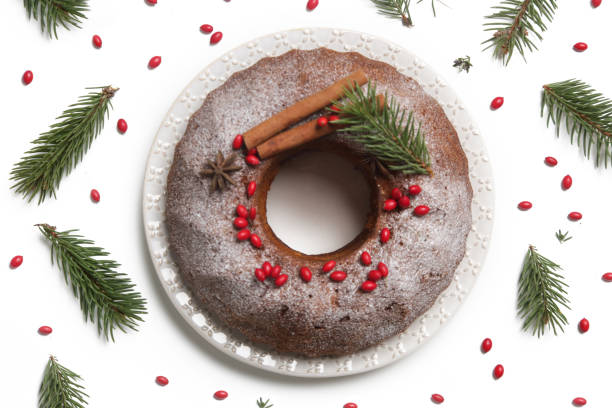 istock Festive bundt cake decorated with red berries and fir branches on white background. 1289473621