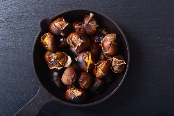 istock Tasty fried chestnut snack background 1289474437