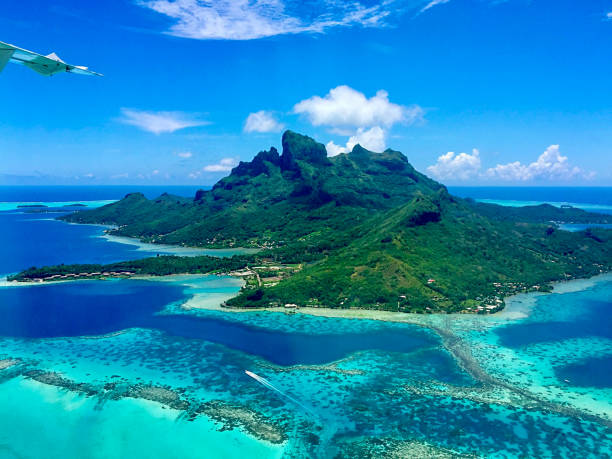 The Amazing Aerial View of the Paradise Bora Bora Island, French Polynesia When flying away from Bora Bora island, the Aerial View of the Paradise Bora Bora Island is truly amazing. Here is Bora Bora Island, the atoll, the lagoon, the resorts and Mt. Otemanu seen from the air. bora bora mountain stock pictures, royalty-free photos & images