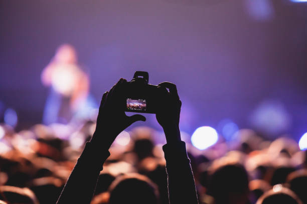 istock A crowded concert hall with scene stage lights, rock show performance, with people silhouette, colourful confetti explosion fired on dance floor air during a concert festival 1289480392