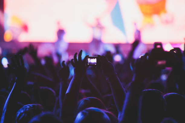 istock A crowded concert hall with scene stage lights, rock show performance, with people silhouette, colourful confetti explosion fired on dance floor air during a concert festival 1289480493