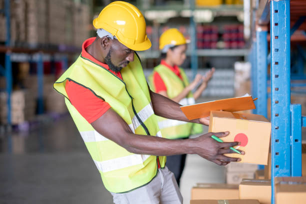 istock African American man stand and hold package box for working in warehouse workplace area with co-worker factory woman 1289490972